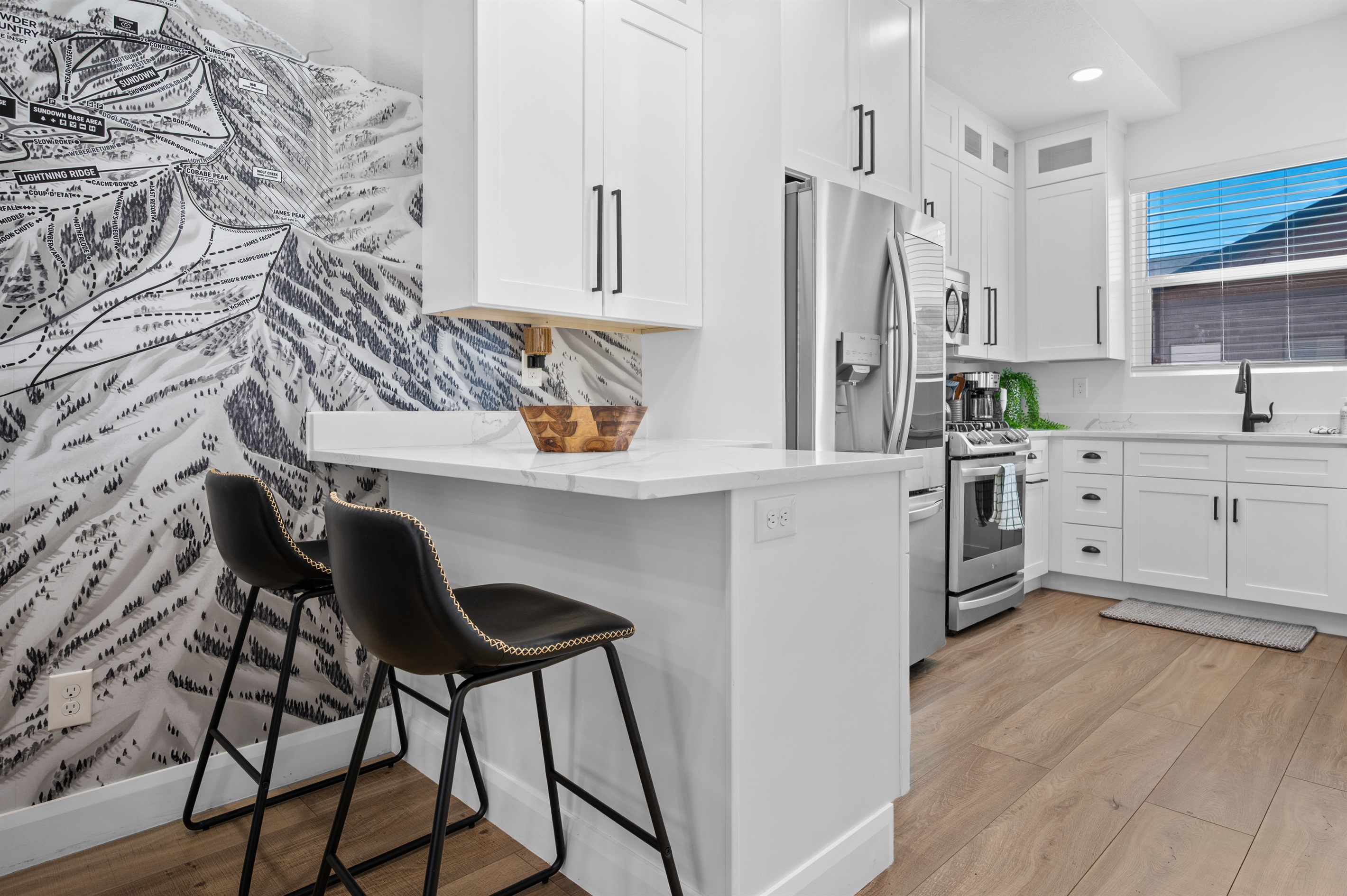 Gourmet kitchen with quartz counters, breakfast bar, and stainless-steel appliances.
