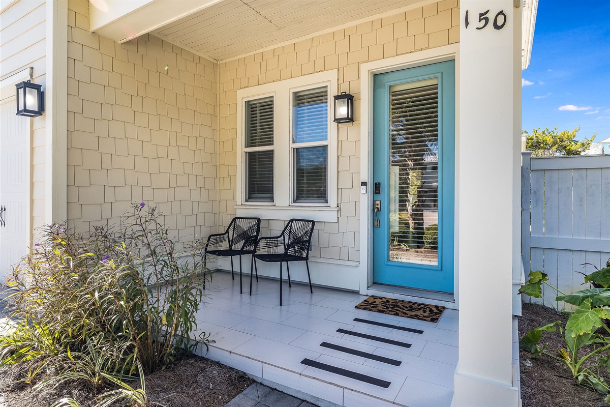 Welcoming front porch with seating and coastal-style entryway.