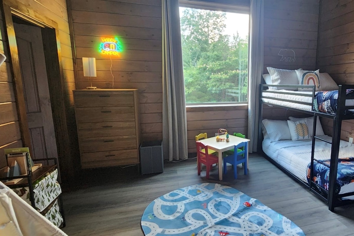 Family-friendly kids’ room with bunk beds, toy table, and cheerful vibes.
