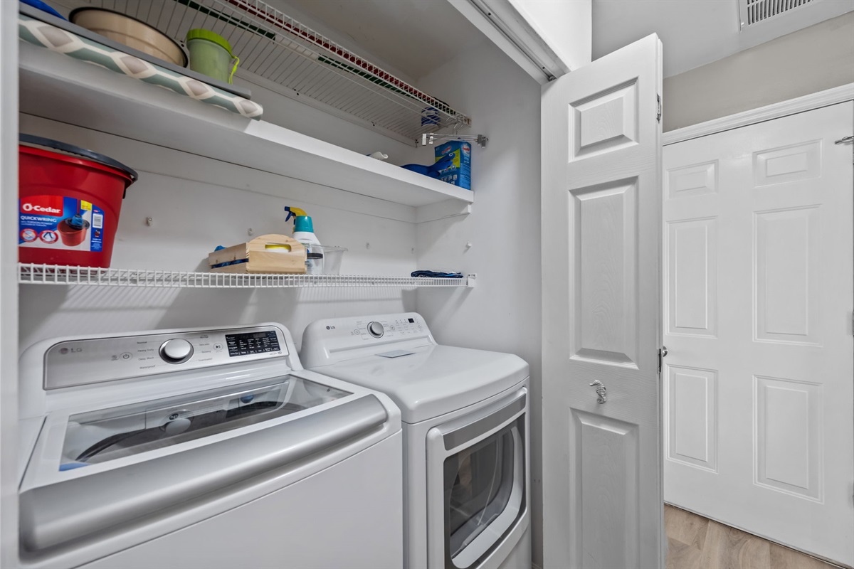 Laundry area with washer, dryer, and storage shelves