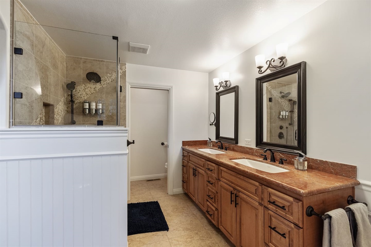 Primary Bedroom ensuite Bathroom: two-sink vanity, standing shower, private toilet room.