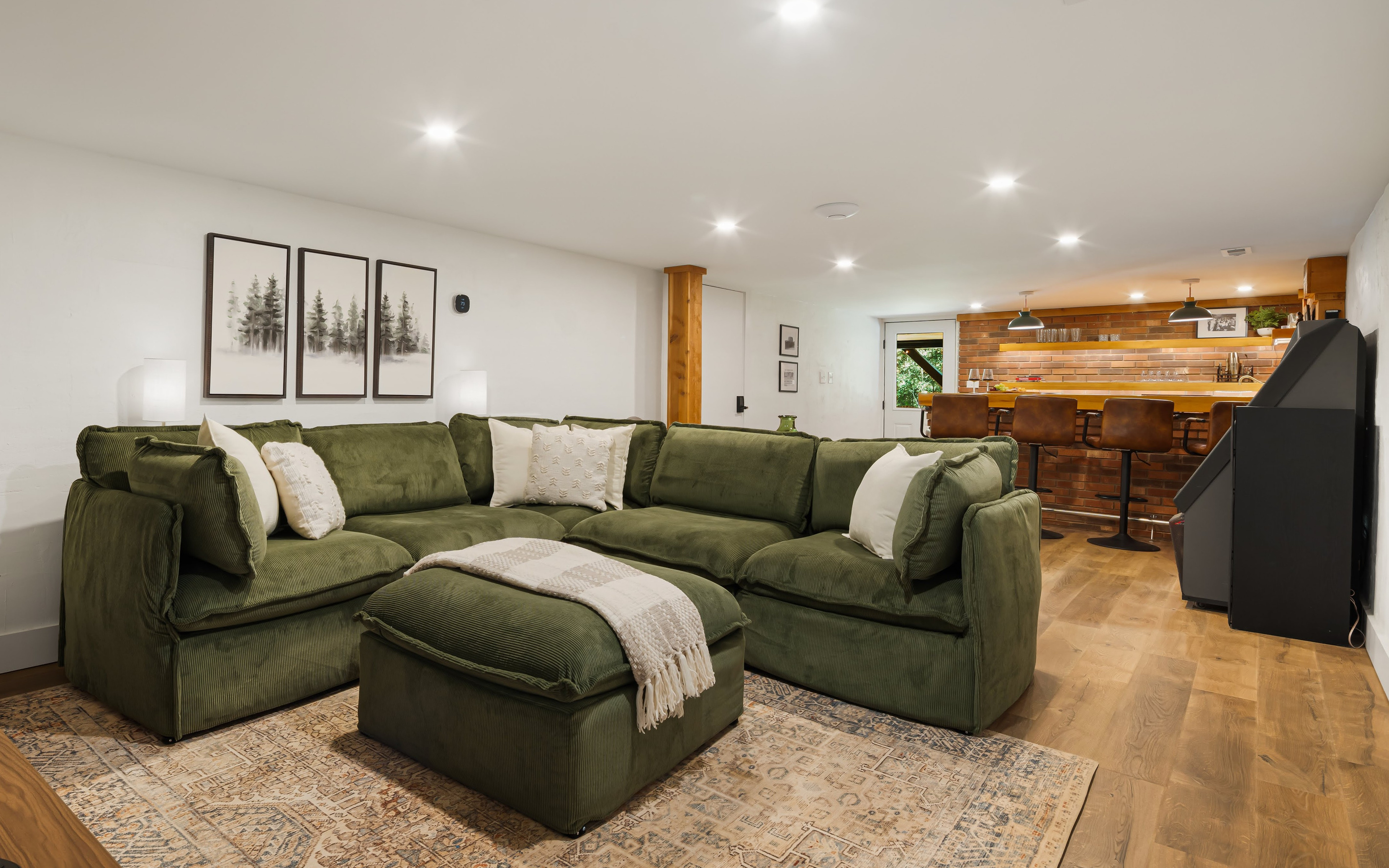 A nice open floorplan of the basement offers lounging and entertaining options with a super cool, restored, vintage jukebox and a speakeasy bar setting with all the equipment needed for entertaining. 