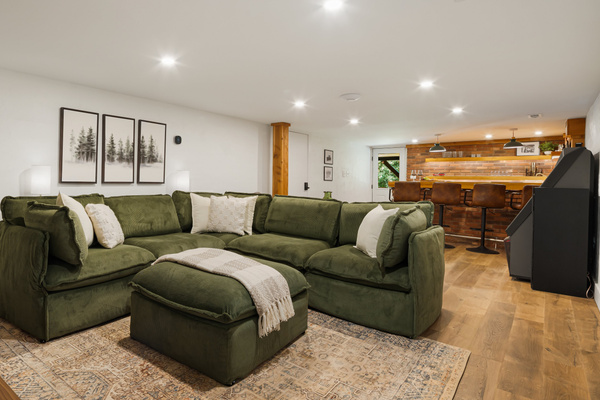 A nice open floorplan of the basement offers lounging and entertaining options with a super cool, restored, vintage jukebox and a speakeasy bar setting with all the equipment needed for entertaining. 