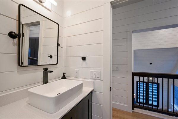 The contemporary vessel sink and matte black faucet create a bold, stylish statement.