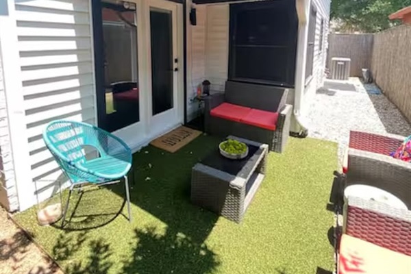 Backyard with patio seating and kid-friendly play space.