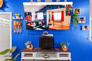 Unwind in a colorful, art-filled living room featuring a PS5 for gaming and streaming
