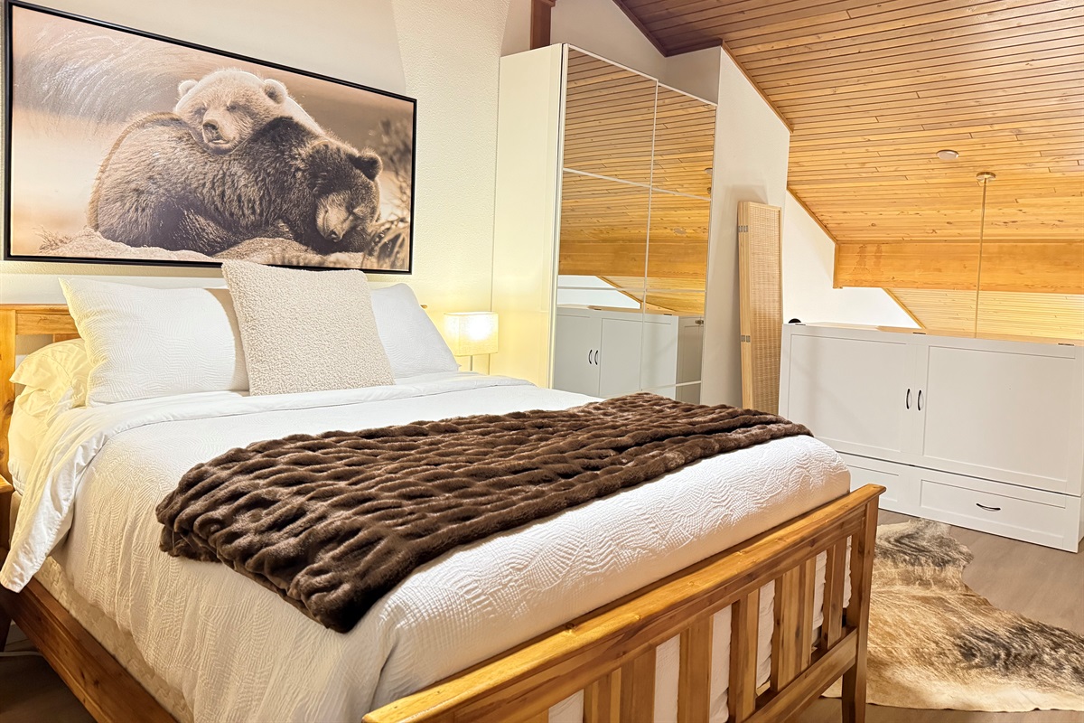 Upper Loft Bedroom: A bright, private bedroom suite with a cozy queen bed, excellent natural light, and convenient access to an en-suite bathroom and closet storage.