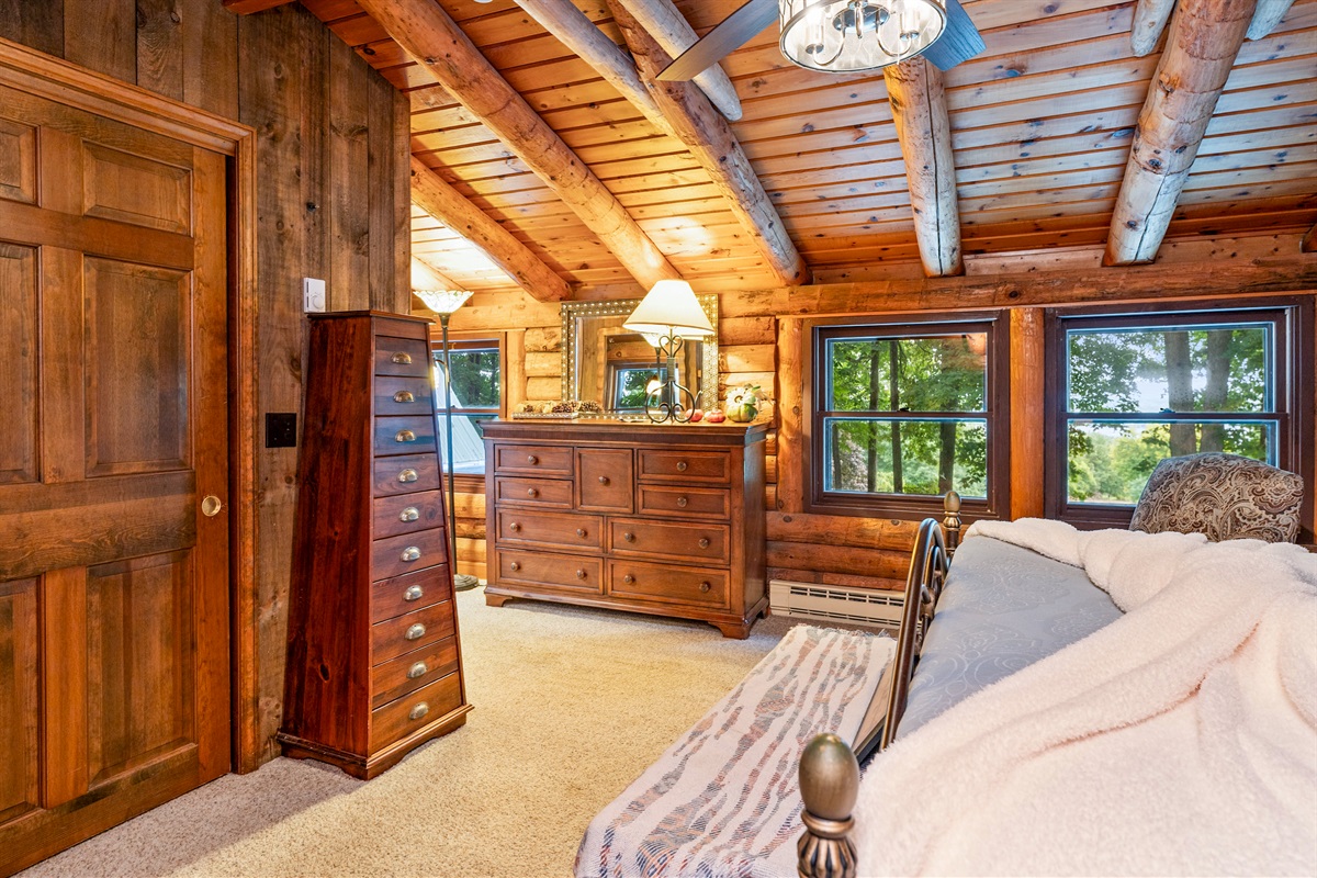 Bedroom #1 Rustic charm meets comfort in this cozy log cabin Master bedroom, featuring a king bed, vaulted ceilings with exposed beams, and serene woodland views. Ensuite bathroom 