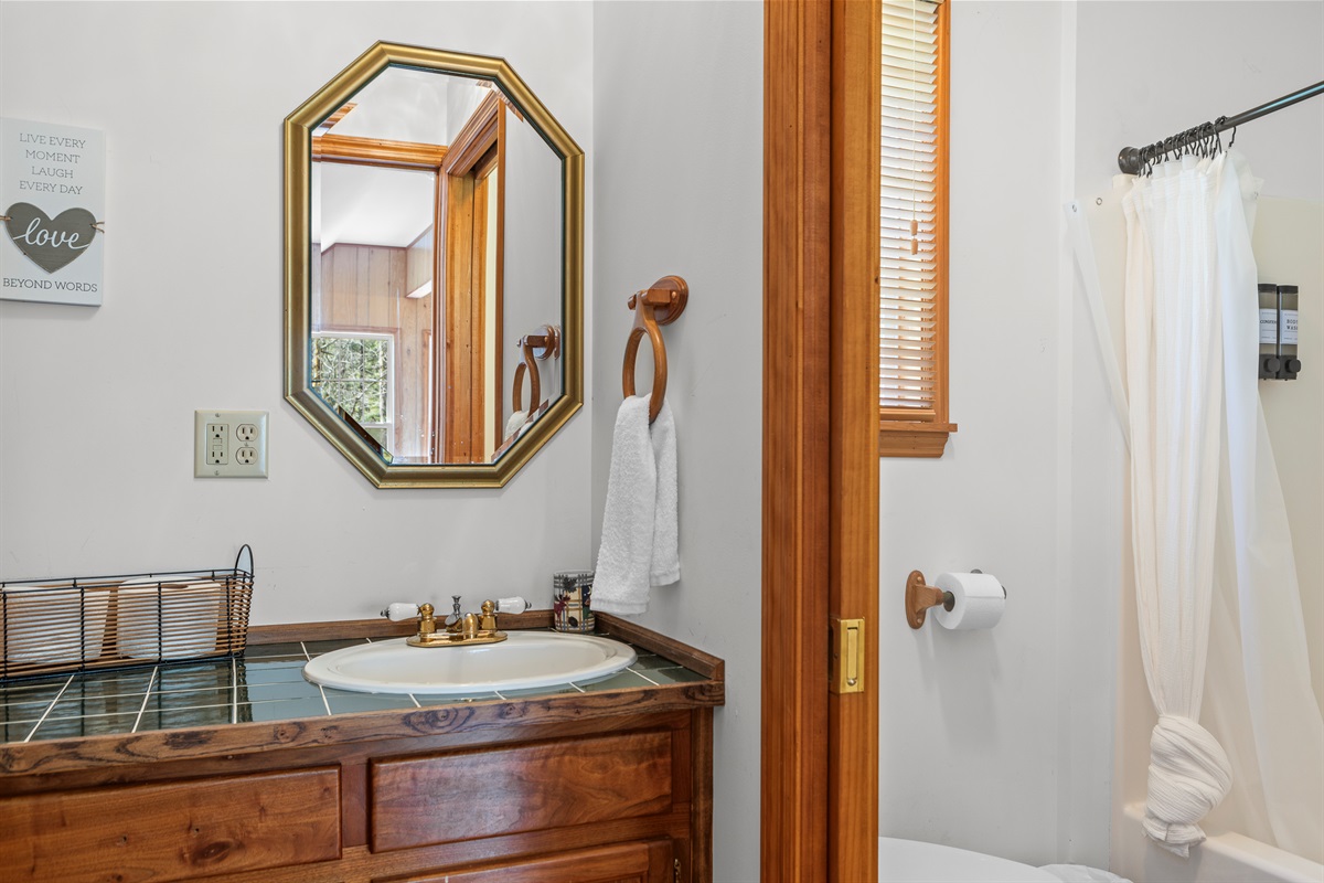 Cottage Full Bathroom 3: Bright space with charming wood accents and a stylish octagonal mirror!