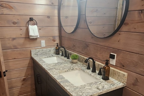 Spacious double vanity with granite countertop and modern fixtures.