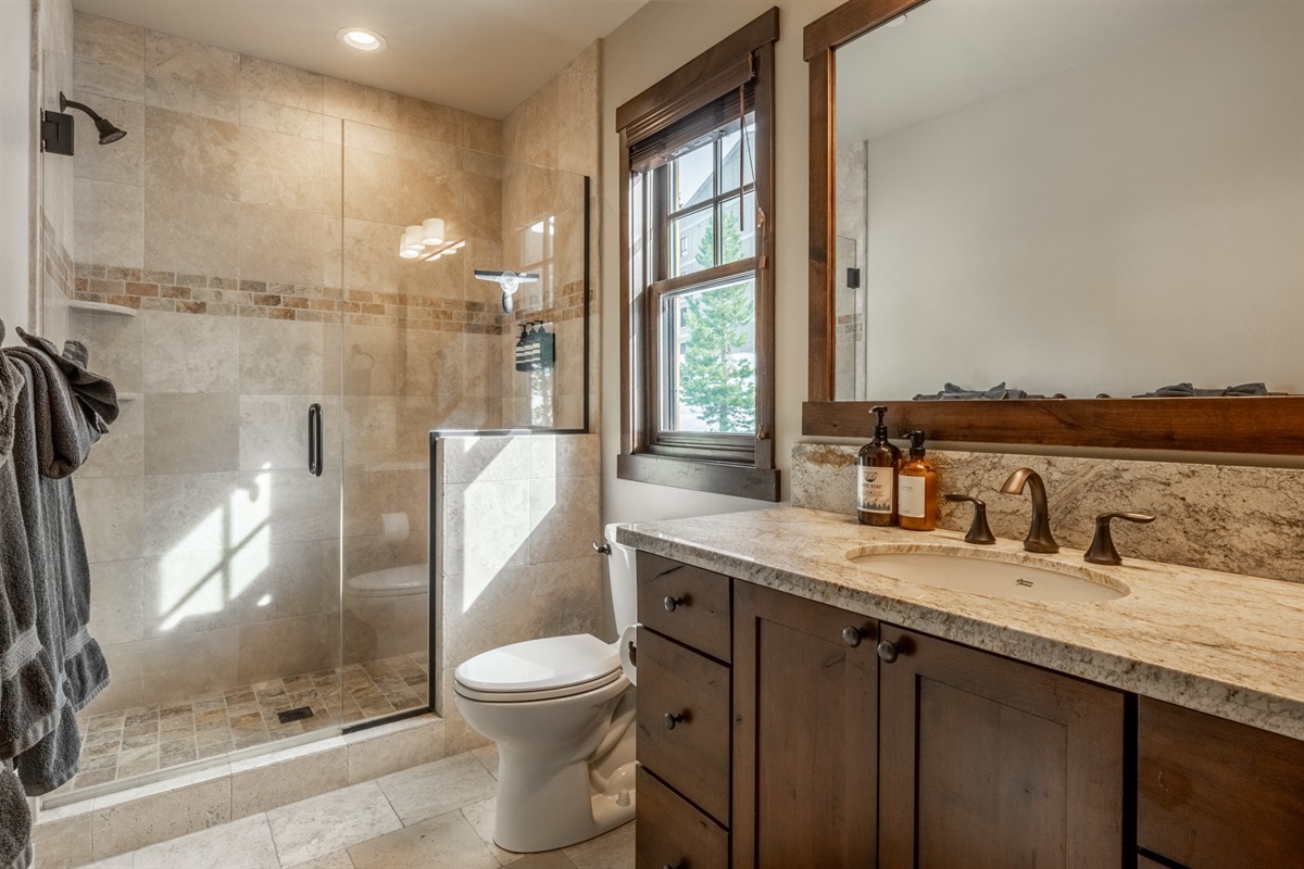 Double Black's second ensuite bath features a sleek walk-in shower, offering both privacy and comfort for additional guests.