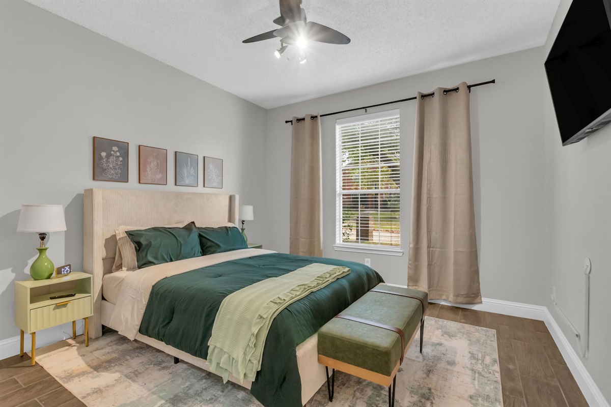 Spacious third bedroom featuring a comfortable queen bed, room-darkening blinds, ceiling fan, fresh bed linens, hangers, and high-speed Wi-Fi.