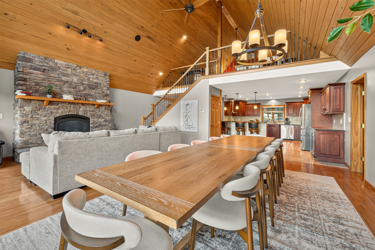 Open living and dining area with stone fireplace