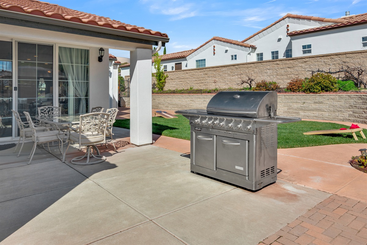 Private backyard patio with fire pit, outdoor dining area, and BBQ grill