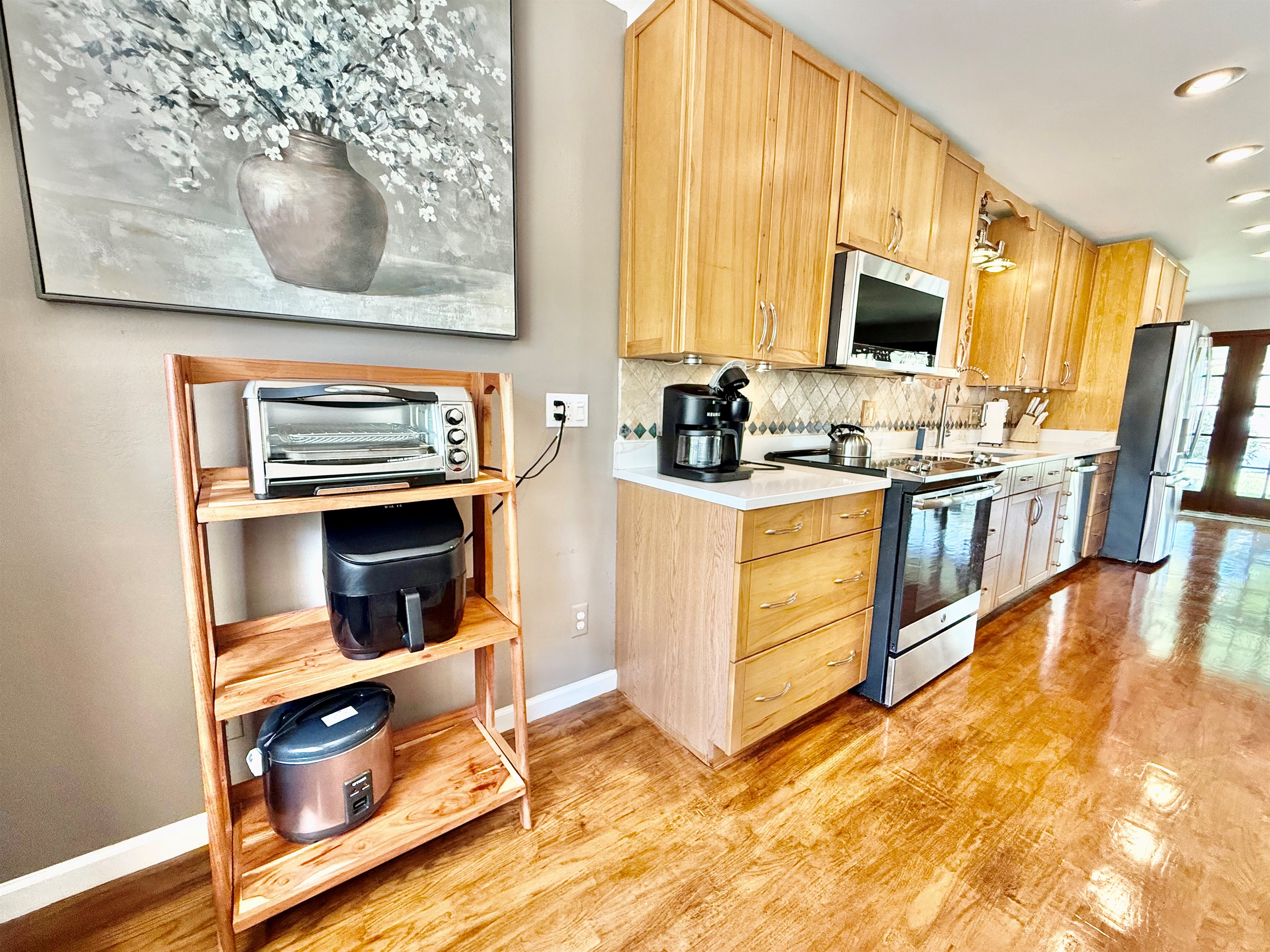 This thoughtfully designed kitchen is both practical and beautiful, featuring a striking tile backsplash, recessed lighting, and everything you need to feel at home.