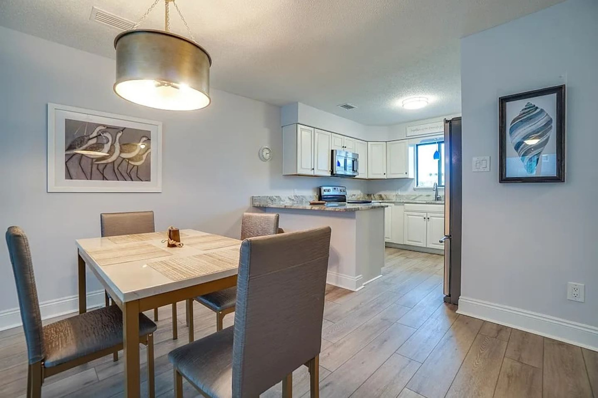 Everyone eats together here &mdash; the dining table seats 8, and the breakfast bar adds extra spots so no one gets stuck at a side table.