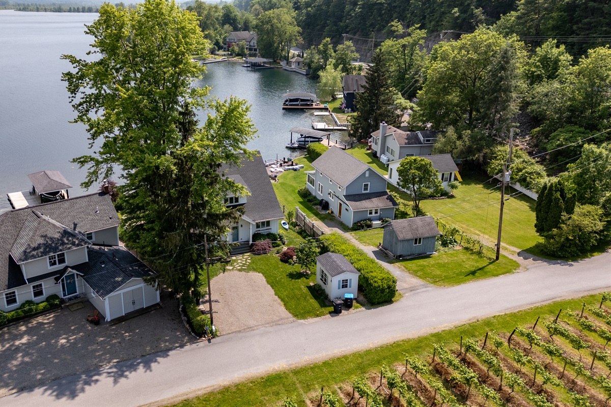 Stunning aerial view of a serene Finger Lakes waterfront retreat, complete with private dock, lush greenery, and charming lakefront homes—perfect for peaceful getaways and water adventures