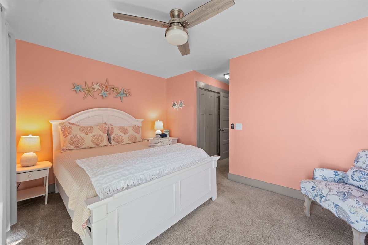 Queen bedroom features warm coastal tones, a comfortable Queen bed, and soft lighting; a relaxing space to unwind after a day at the beach