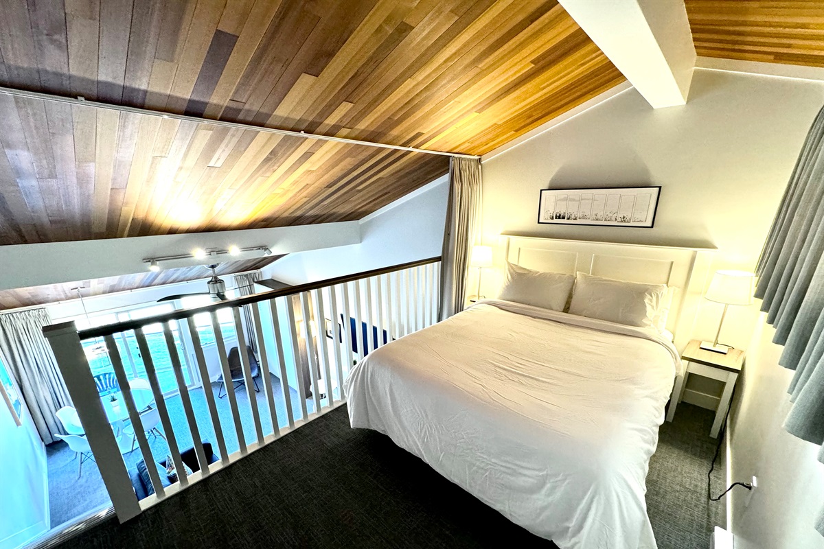 A comfy queen-sized bed in the loft. 1 of 3 beds in the Suite. 