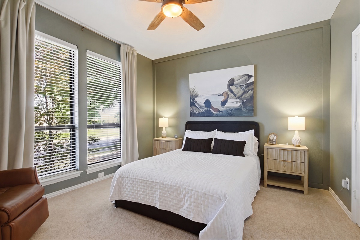 Guest Bedroom 2 with a Queen Bed, 55-inch Smart TV, leather recliner, and a dedicated workspace with desk and office chair, ideal for remote work or evening downtime.
