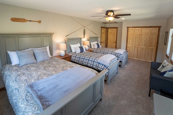 Upstairs Bedroom 4 is spacious with two queens and a twin, perfect for family stays.Tasteful decor and cozy ambiance make it a perfect sanctuary.