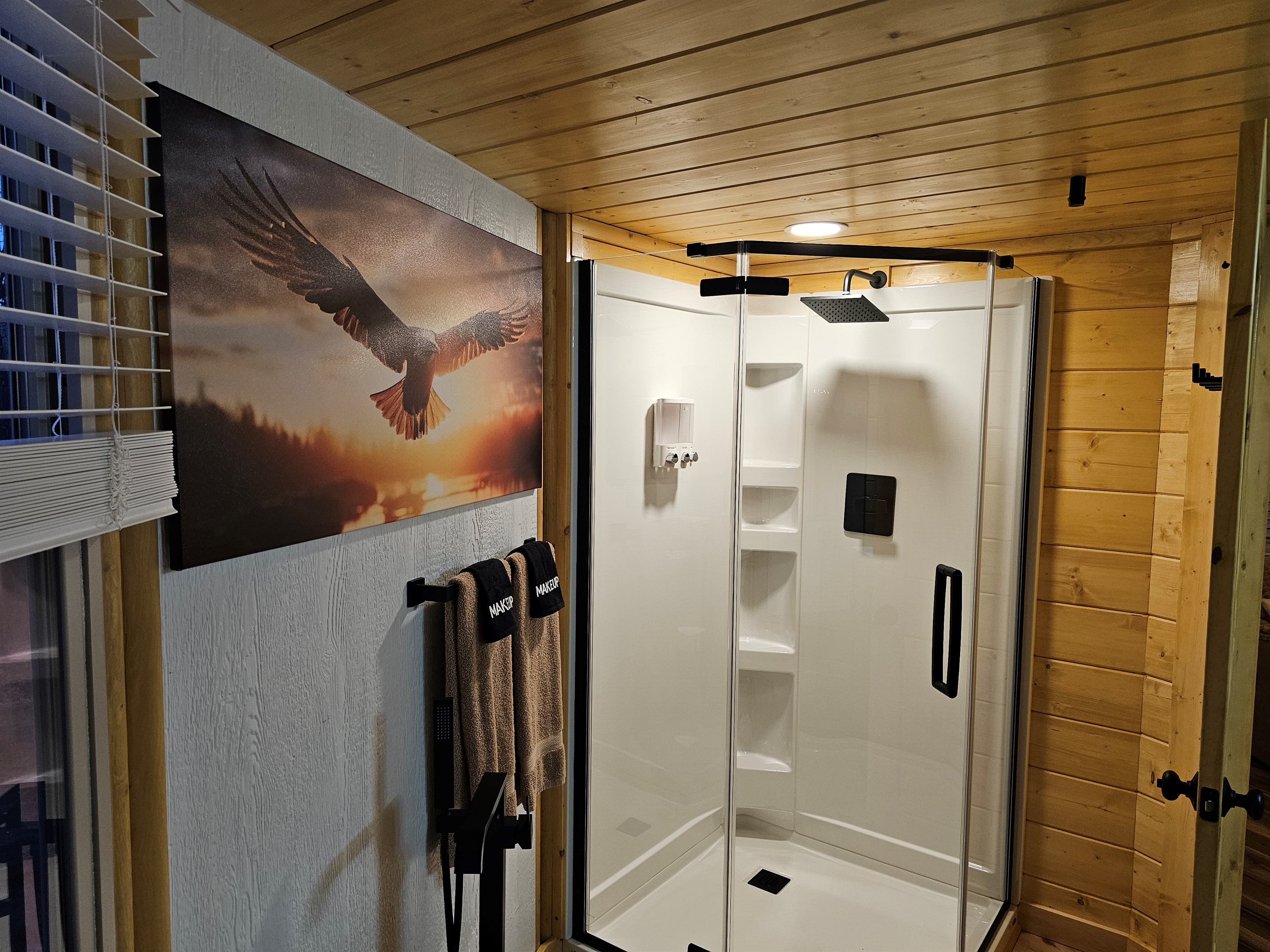 Refresh in the modern walk-in shower with a rainfall showerhead, clean lines, and warm wood accents—an inviting spa-style space designed for comfort and relaxation.