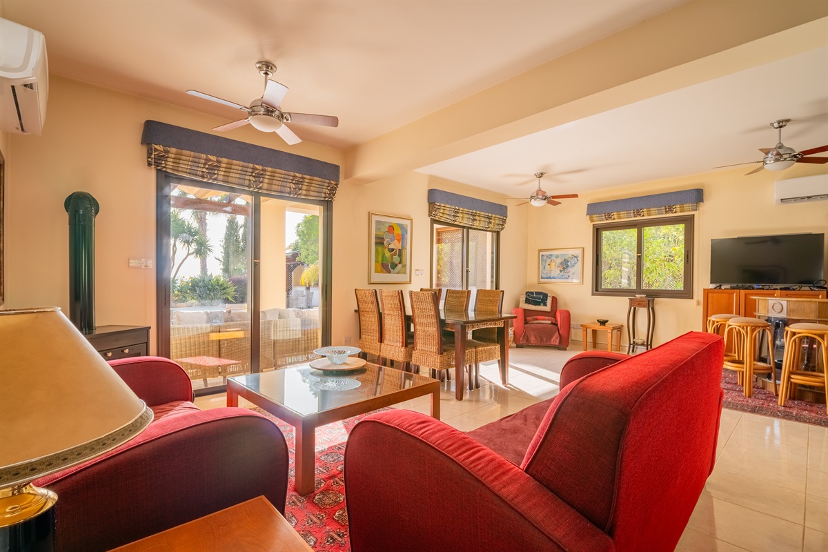 Bright and airy living space featuring plush seating, and direct access to the patio and garden. Perfect for relaxing or entertaining, with a dining table and bar seating to accommodate everyone.