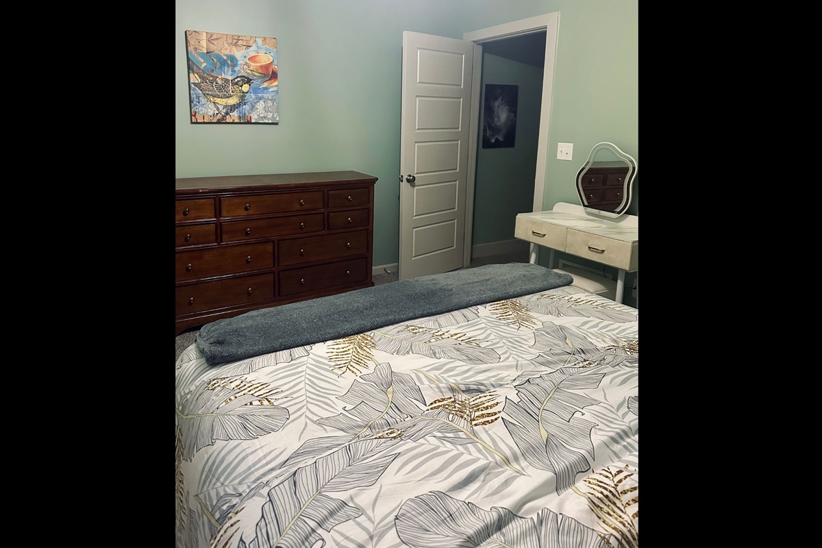 Alternate angle of the welcoming queen bedroom, highlighting its calm atmosphere and spacious layout.
