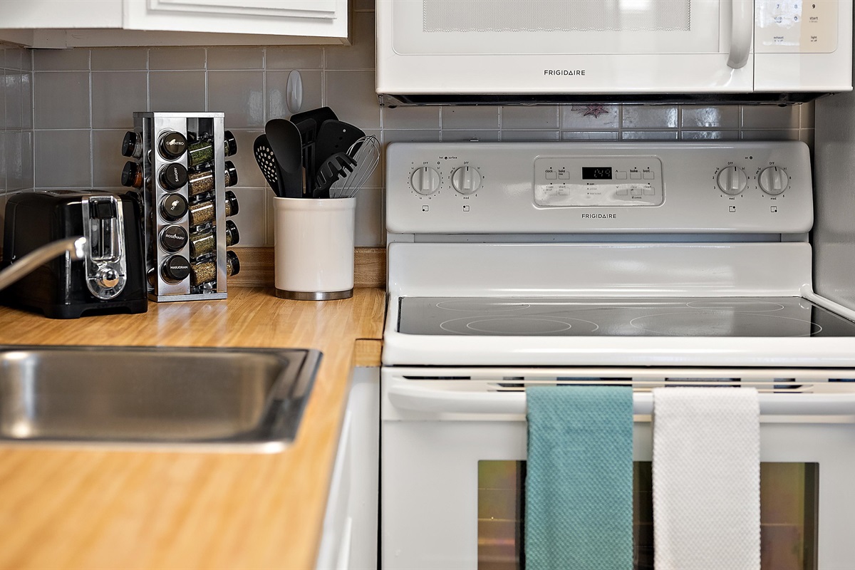 Cooking utensils and spices at your fingertips. With an additional toaster oven in the cabinet