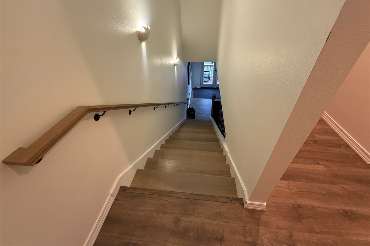 Stair hall is wooden with wooden railings. 