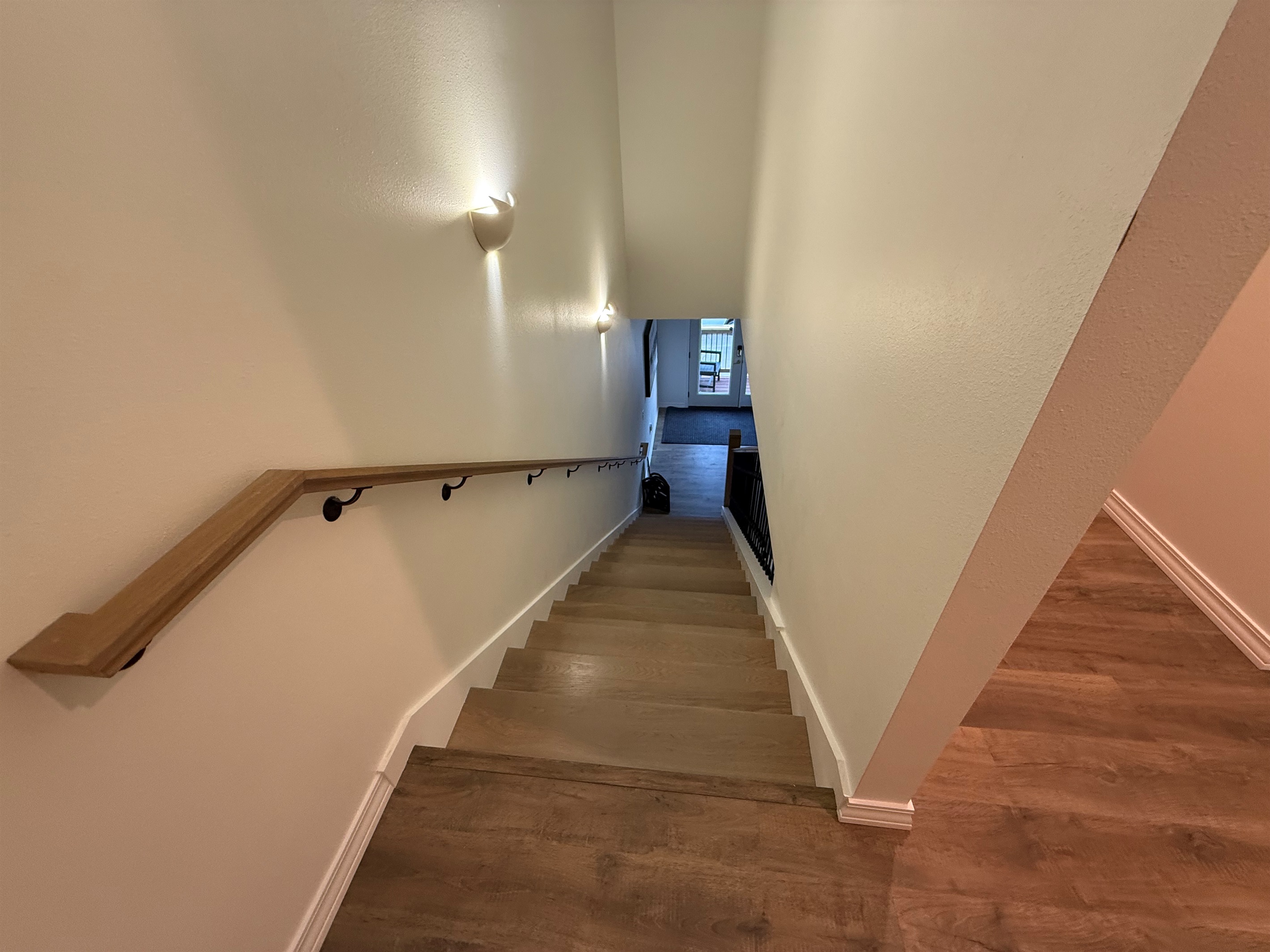 Stair hall is wooden with wooden railings. 