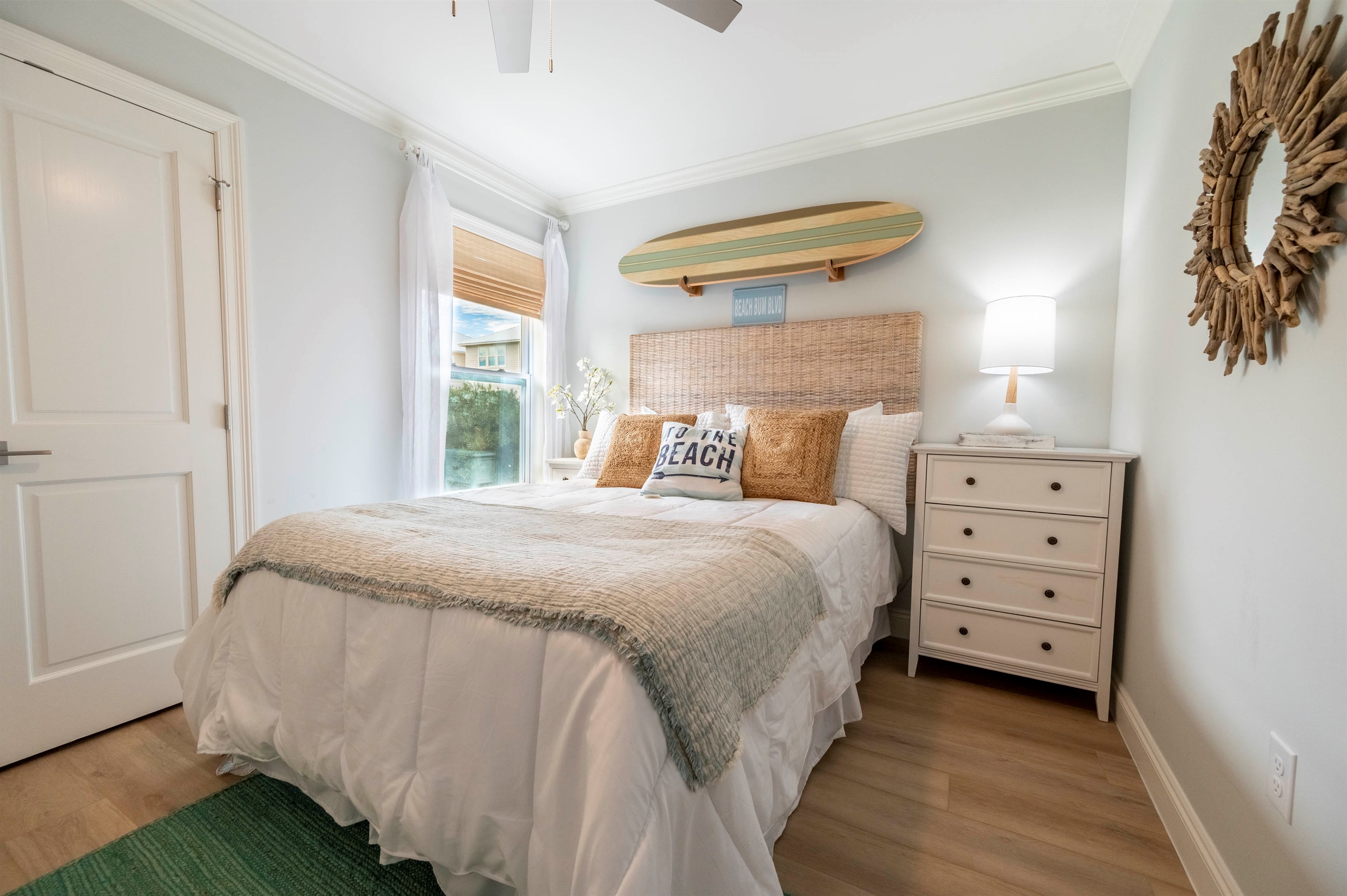 Bright beachy bedroom with surfboard decor and a cozy, sunlit ambiance.

