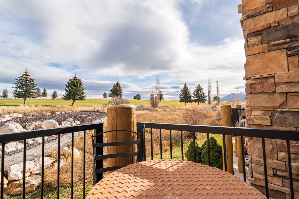 A peaceful balcony retreat overlooking open space and mountain scenery.