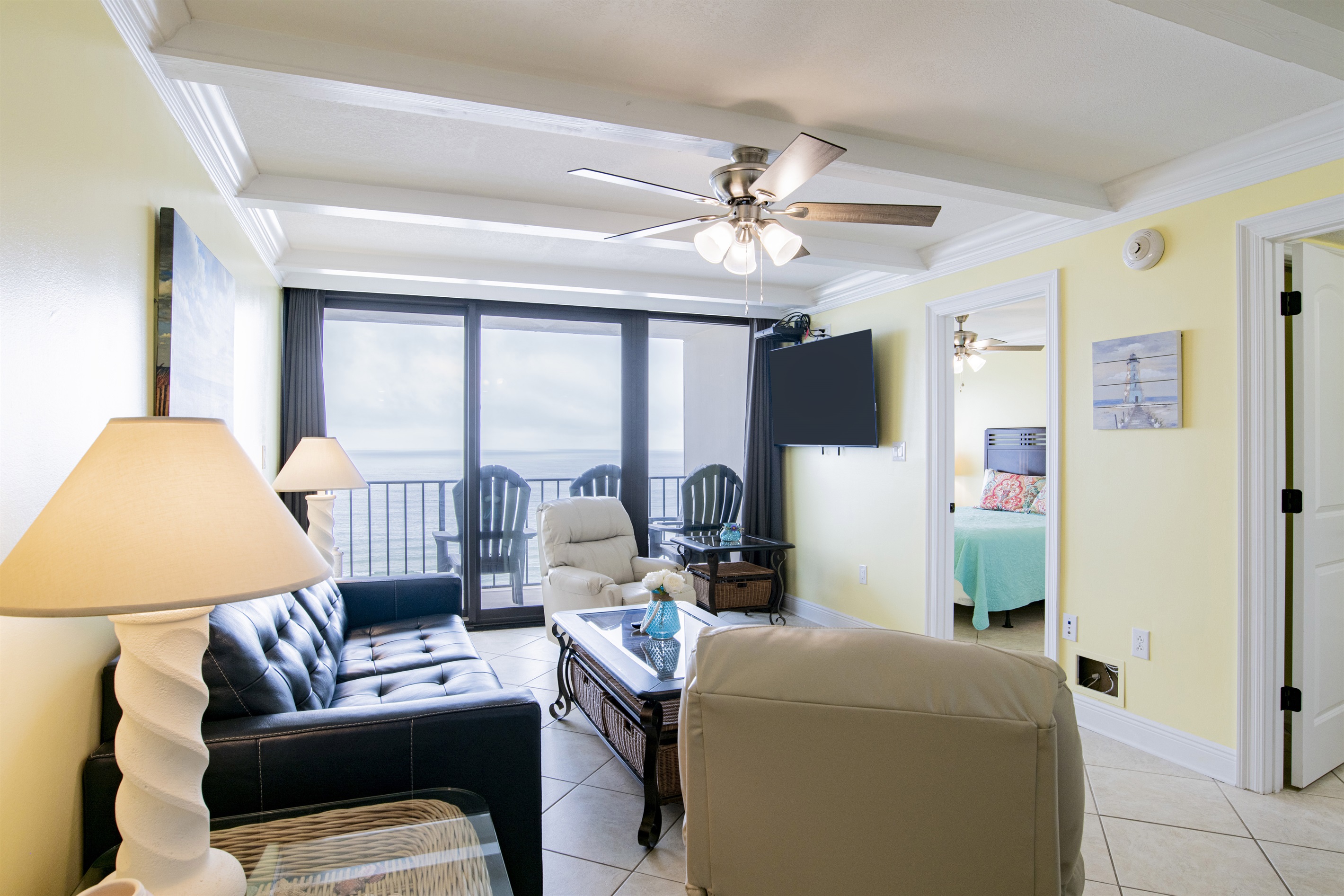 Living Room with A Great View. It Has A Queen Size Leather Sleeper Sofa, 2 Swivel/Rocker Recliners, 3 End Tables, A Coffee Table, A 58" Wall Mounted Smart TV And Balcony Access