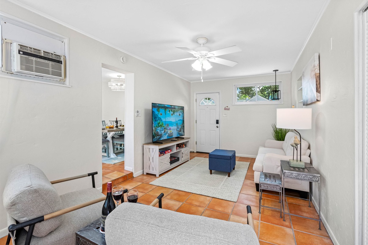 Unwind in this bright and cheerful lounge area featuring cozy seating, vibrant tile floors, and a smart TV for movie nights or quiet downtime.