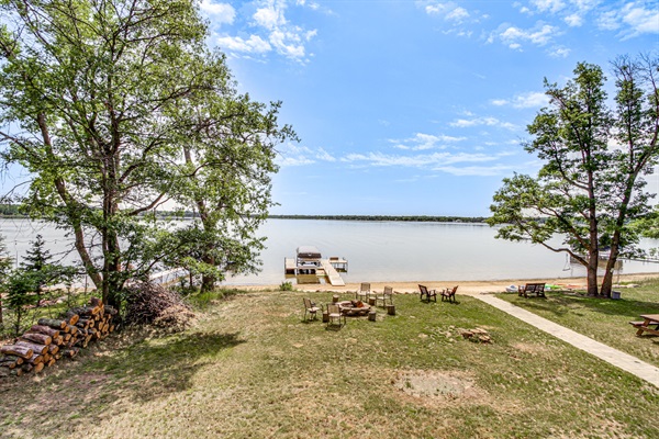 Panoramic lakefront views with private dock, sandy shoreline, and wide-open water—perfect for swimming, boating, and sunsets