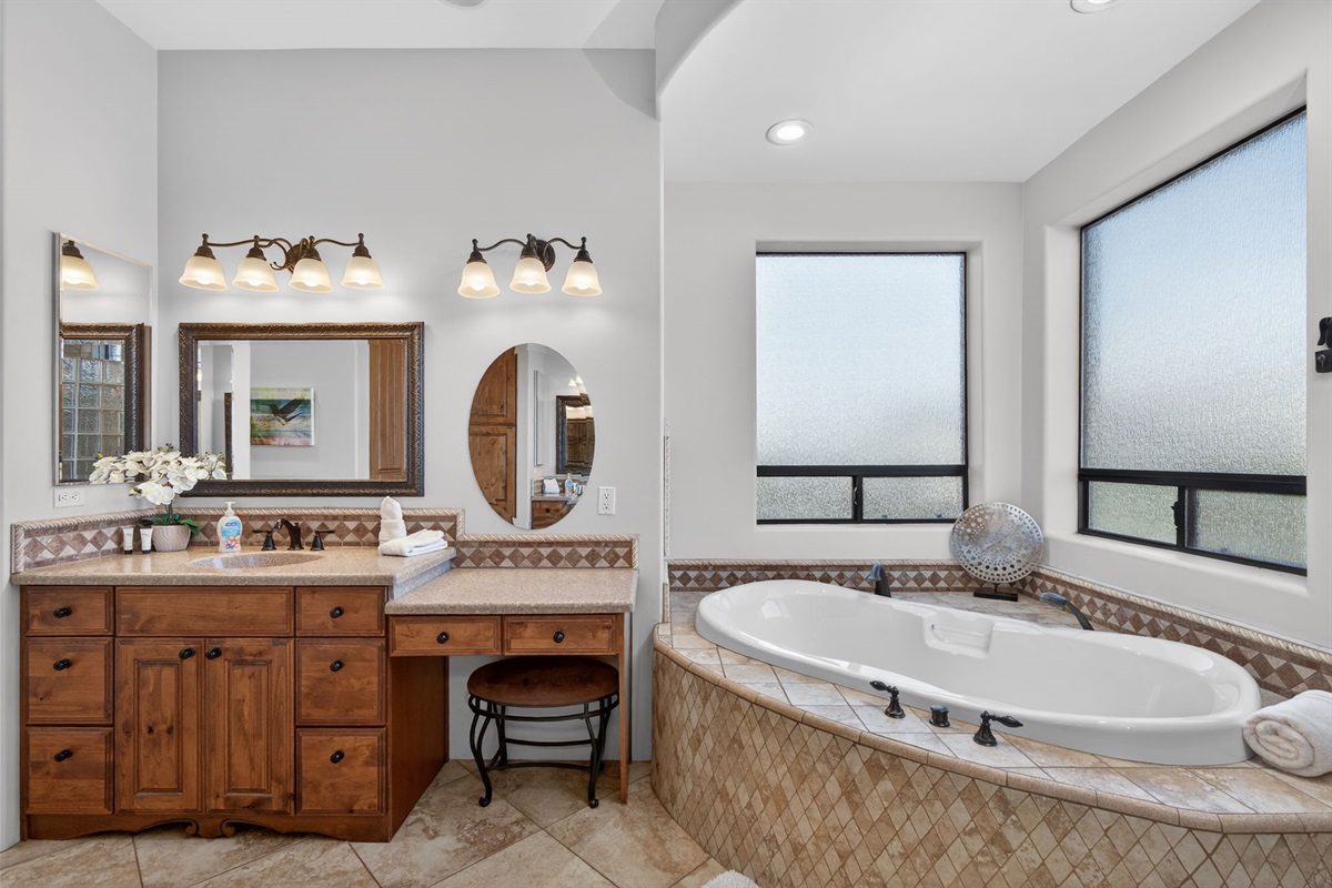 Luxury ensuite bathroom with dual vanity and soaking tub provides plenty of space for getting ready with ease