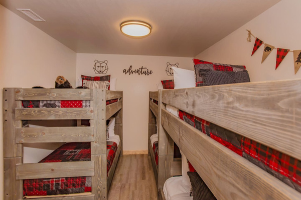 Rows of sturdy wood bunks in red plaid. Pick a bunk, any bunk, Splashing at the Bluff