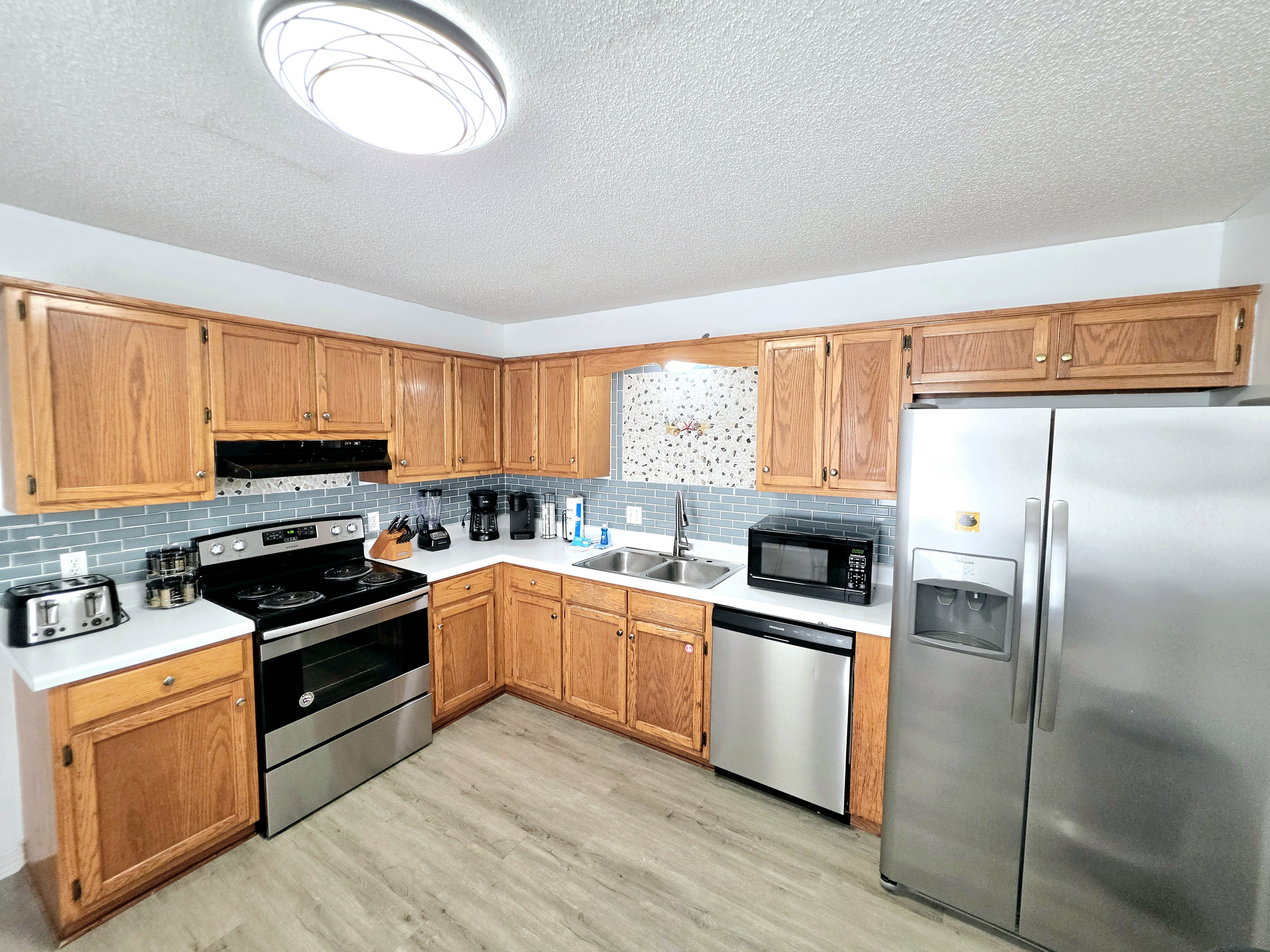 Nest side – Kitchen with stainless appliances and tile backsplash