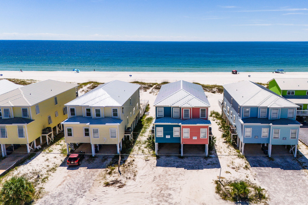 Aerial view of colorful beach vacation homes in a relaxing coastal community near the beach.