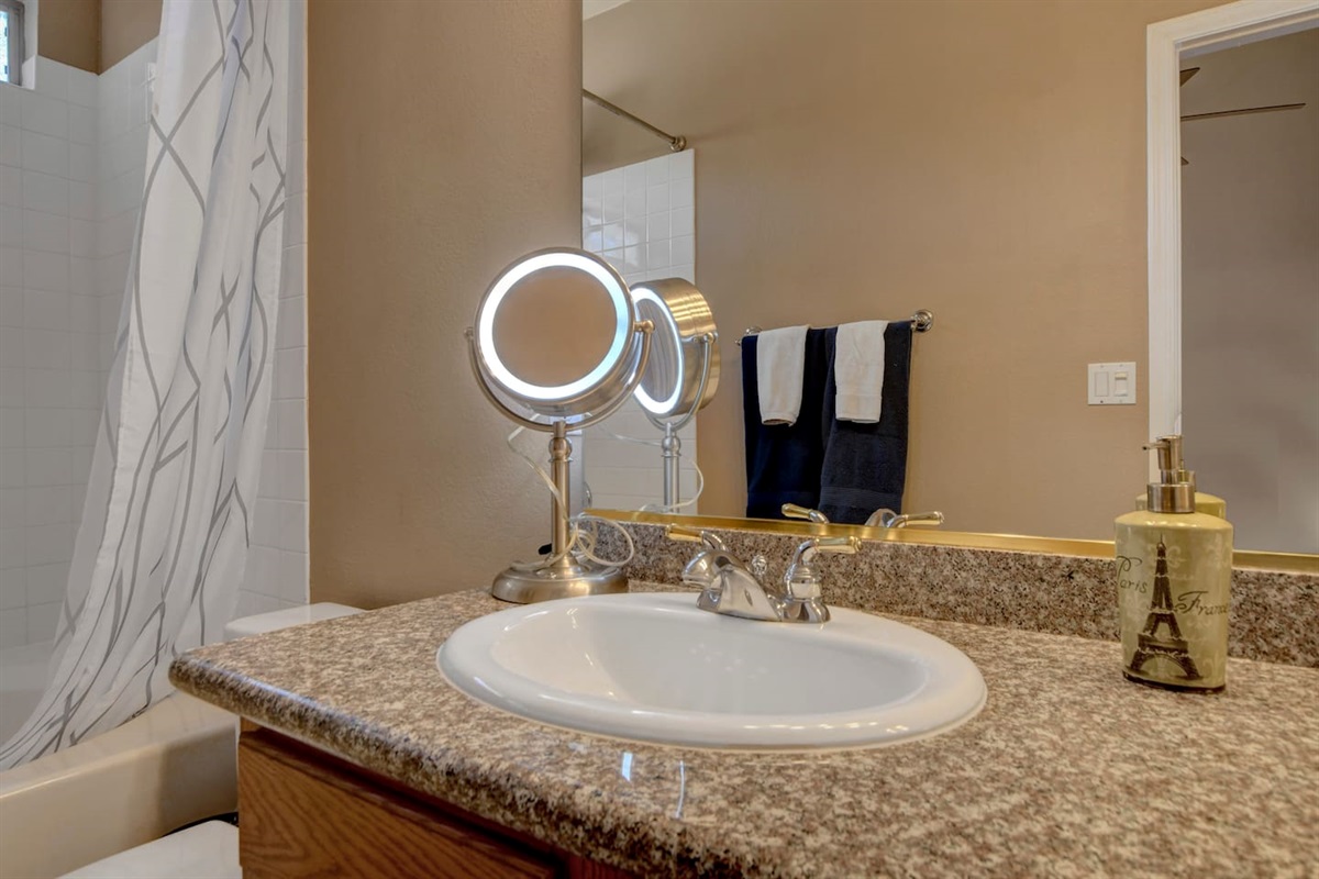 Sparkling bath with granite vanity, lighted mirror & tiled shower