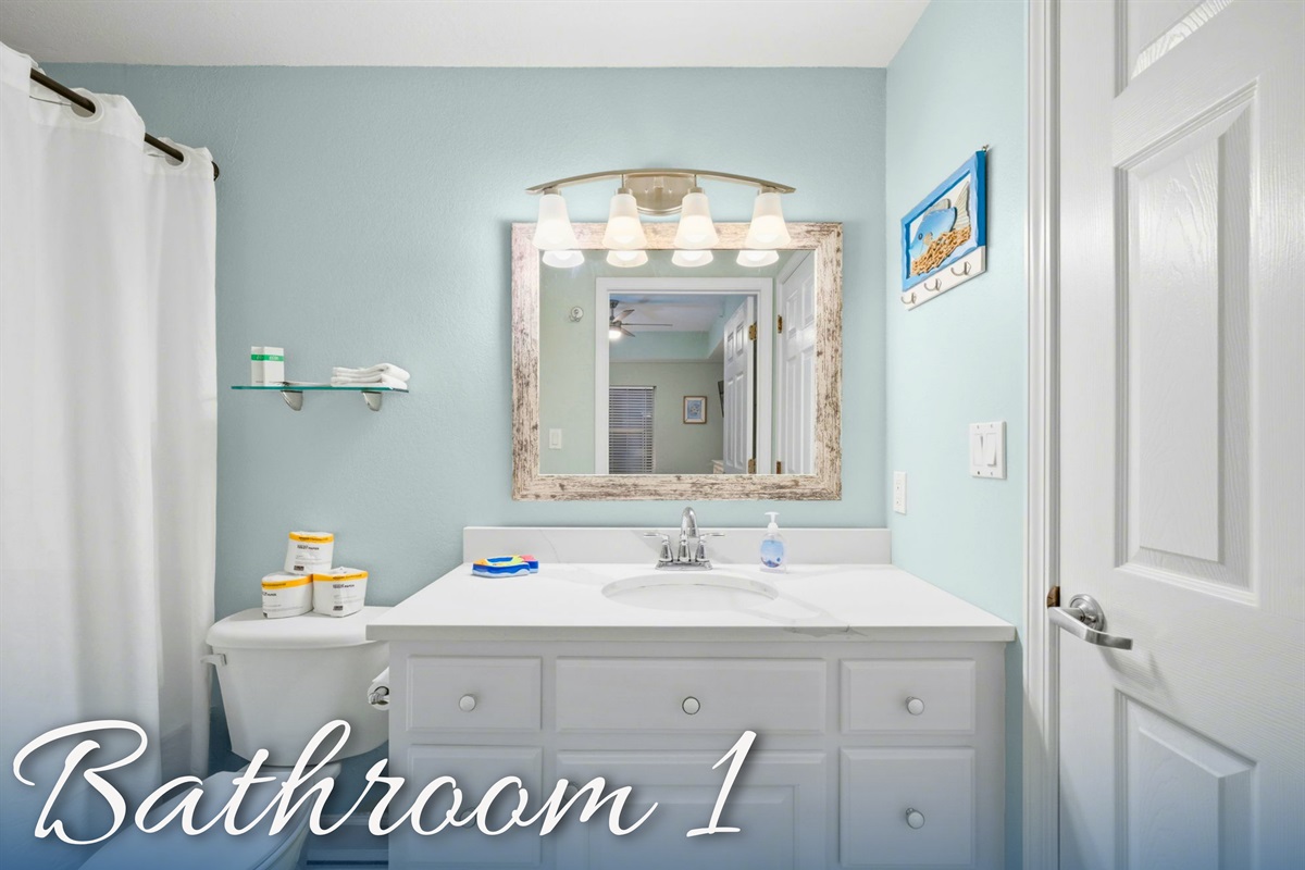 Bathroom 1 includes a large vanity and everything needed to get ready for a day by the water.