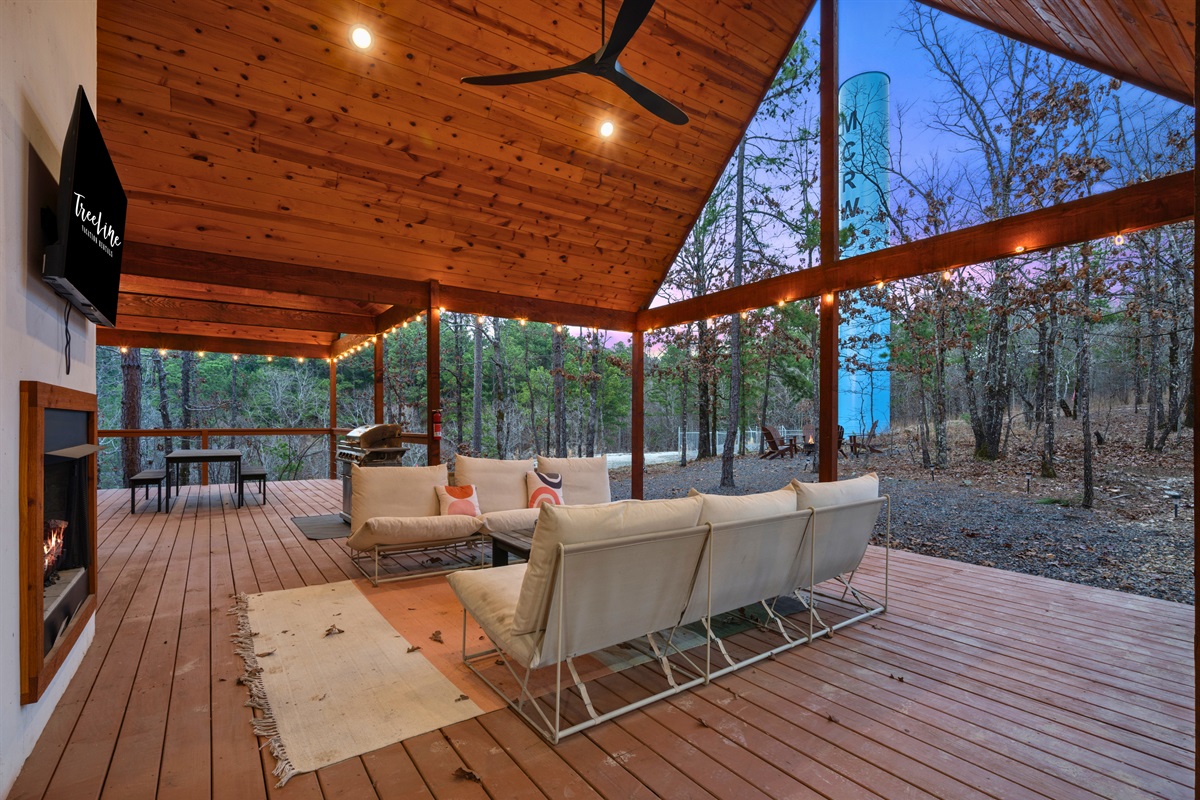The covered deck offers a comfortable outdoor lounge area where you can relax, enjoy the fresh air, and take in the peaceful woodland setting.