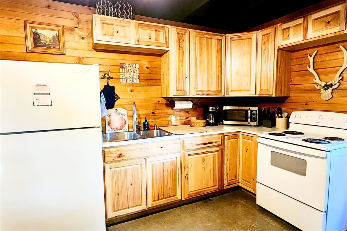 This rustic kitchen is fully stocked for your stay with a full-size fridge, oven, microwave, coffee maker, and cookware. Knotty pine cabinets and lodge-inspired touches make it both functional and welcoming for everything from snacks to full meals.