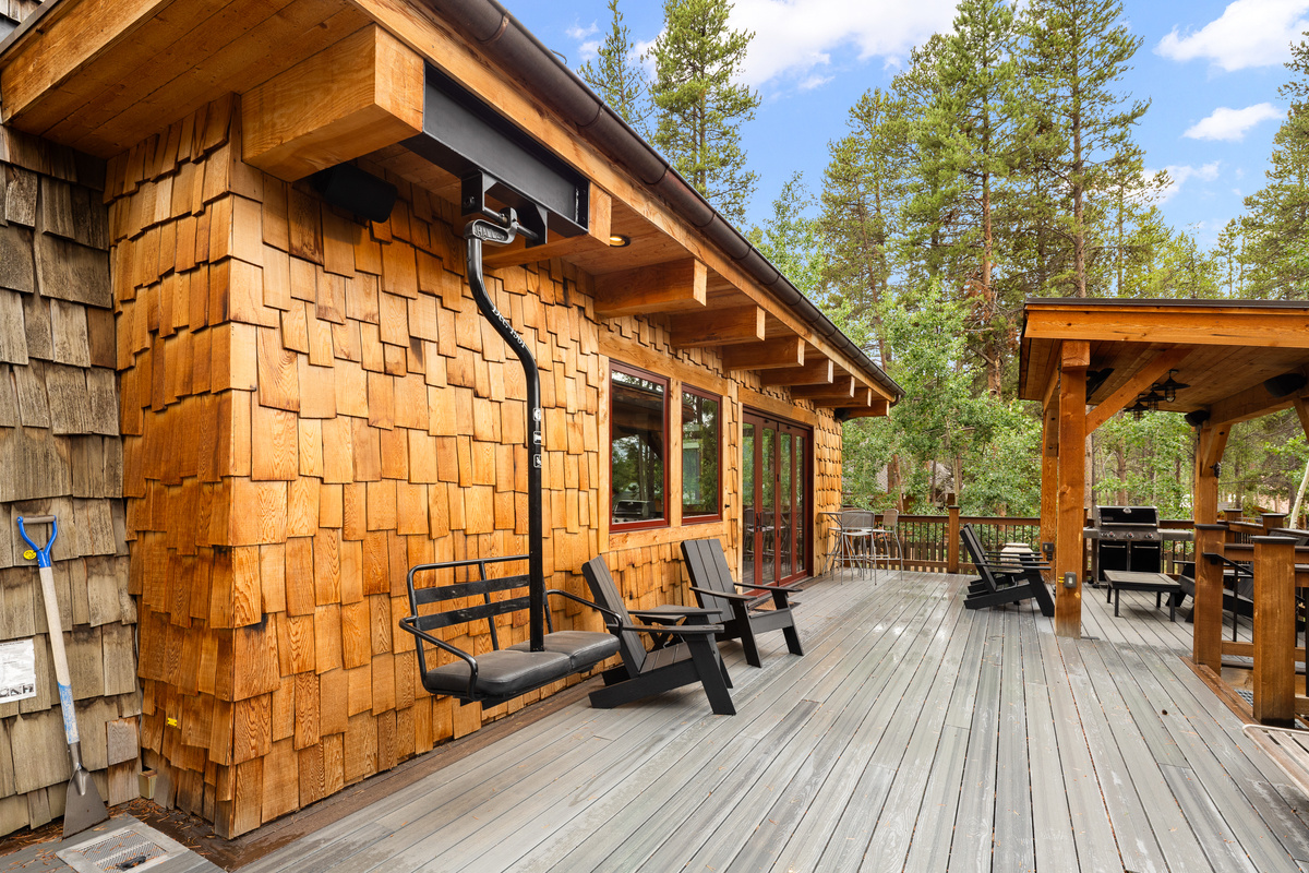 Chairlift swing and lounge seating on spacious deck in outdoor living space in rear of home