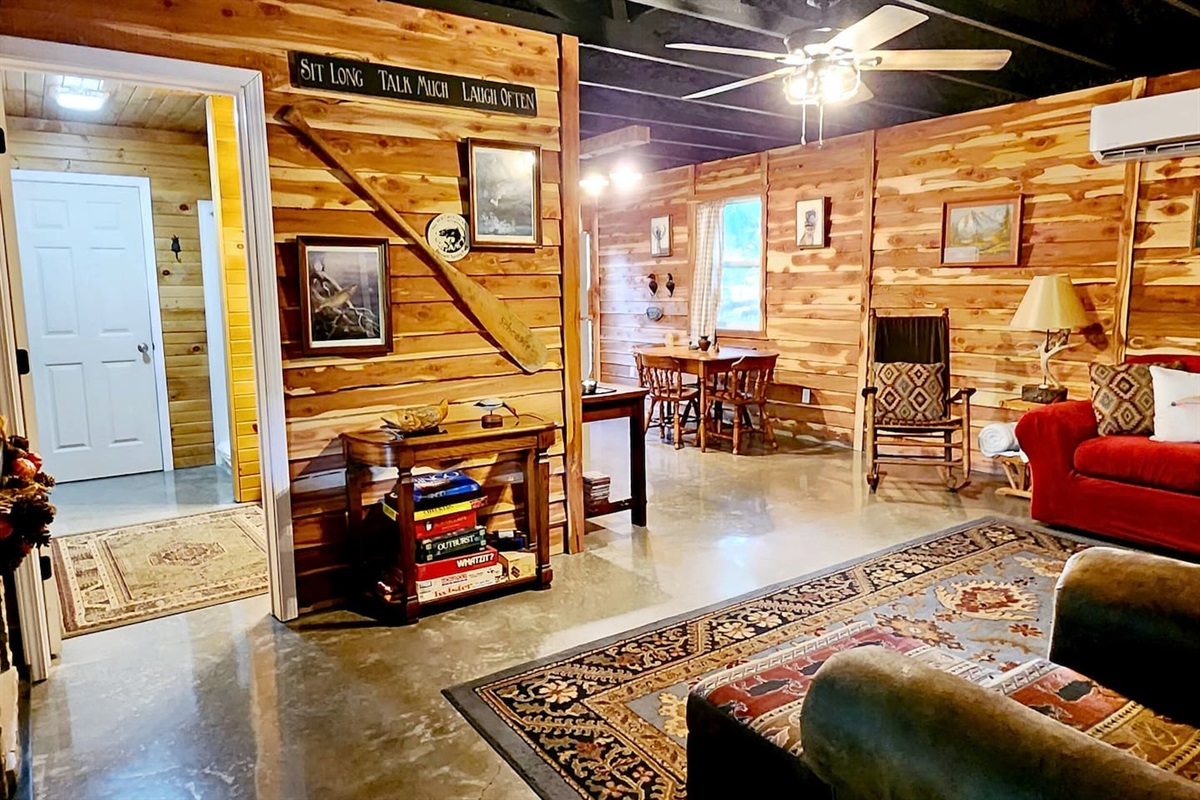 Warm cedar walls and polished concrete floors set a rustic-modern tone in the lodge’s open living area. A red sofa, rocker, and games invite you to sit back, unwind, and enjoy good company beneath the soft glow of vintage lamps and ceiling fans.
