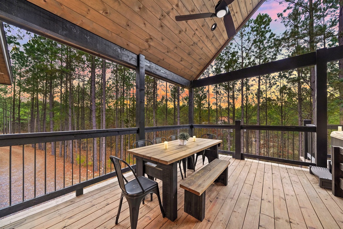 Spacious deck with outdoor dining table overlooking forest views.