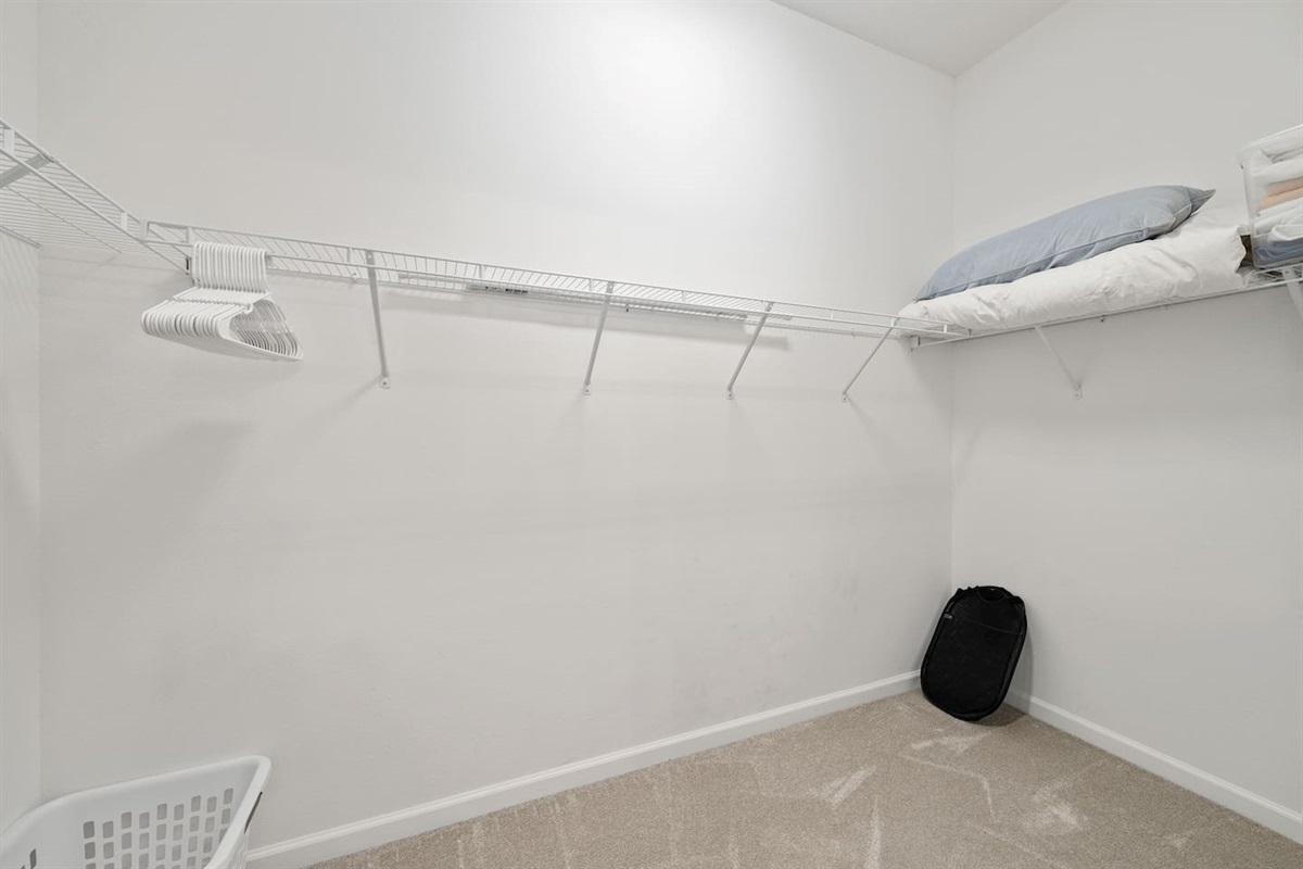 Spacious master closet with extra pillows and blankets.