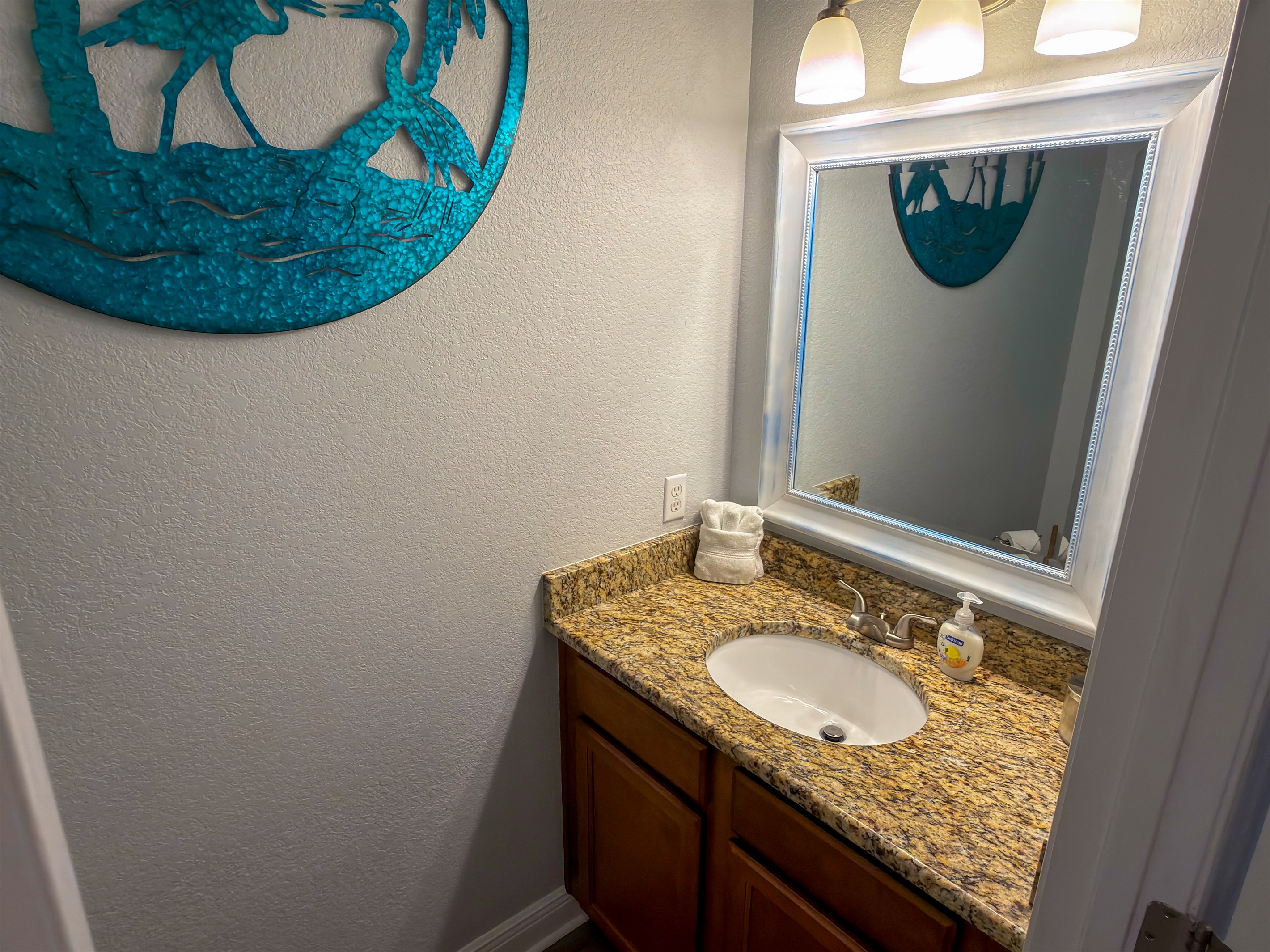 Located off the main hallway, the guest powder room is thoughtfully designed with warm lighting and upscale finishes.