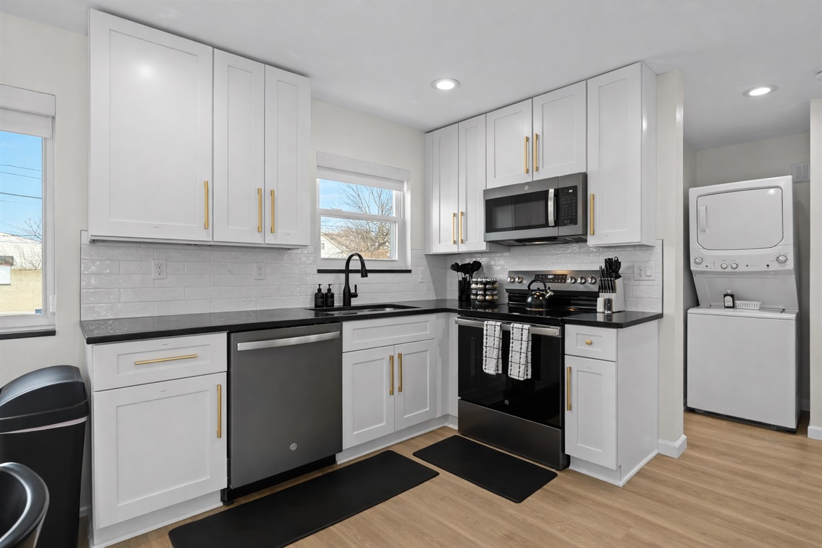 Bright, fully equipped kitchen with modern appliances, sleek finishes, and in-unit laundry—designed for easy meals and extended stays.